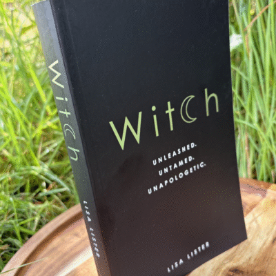 The book "Witch" standing upright against a grassy background, with silver-green title text and the subtitle "Unleashed. Untamed. Unapologetic.