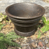 Close-up of an aged cast iron cauldron with ritual herbs and flowers, perfect for witchcraft and spellwork.