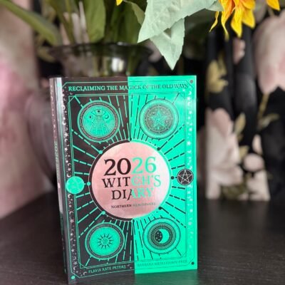2026 Witch’s Diary standing in front of sunflowers and a dark floral background, mystical and vibrant.
