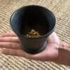 Hand holding an antique cast iron cauldron, showcasing its size and textured patina.Hand holding an antique cast iron cauldron, showcasing its size and textured patina.