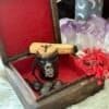 Open antique altar box with red velvet lining, holding runes, herbs, and a spell jar in a magical altar setting.