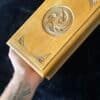 Hand holding vintage carved wooden box with swirling design.