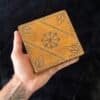 Two hand-carved vintage wooden boxes with mystical designs, perfect for tarot cards, crystals, or as a travel altar. A hand holding the box.