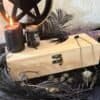 Unfinished handcrafted wooden box with metal clasp, displayed with black candle, runes, and feathers – perfect for witchcraft tools, tarot cards, or personalized altar storage.