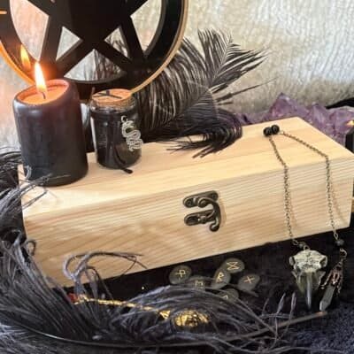 Unfinished handcrafted wooden box with metal clasp, displayed with black candle, runes, and feathers – perfect for witchcraft tools, tarot cards, or personalized altar storage.