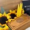 A handcrafted wooden witchcraft storage box surrounded by sunflowers, yellow candles, and a witchcraft book – perfect for tarot cards, crystals, and altar tools.