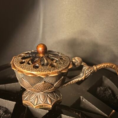 bronze incense burner with glowing charcoal and burning herbs, used for ritual and cleansing