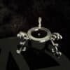 Silver crystal ball stand with ornate detailing, displayed on a black pentacle background.