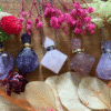 Collection of crystal bottle necklaces with intention oils – amethyst, rose quartz, and carnelian talismans with chains
