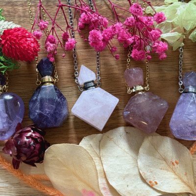 Collection of crystal bottle necklaces with intention oils – amethyst, rose quartz, and carnelian talismans with chains