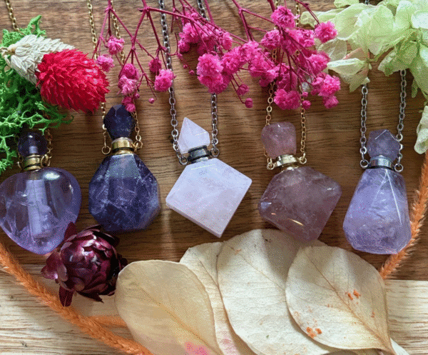 Collection of crystal bottle necklaces with intention oils – amethyst, rose quartz, and carnelian talismans with chains