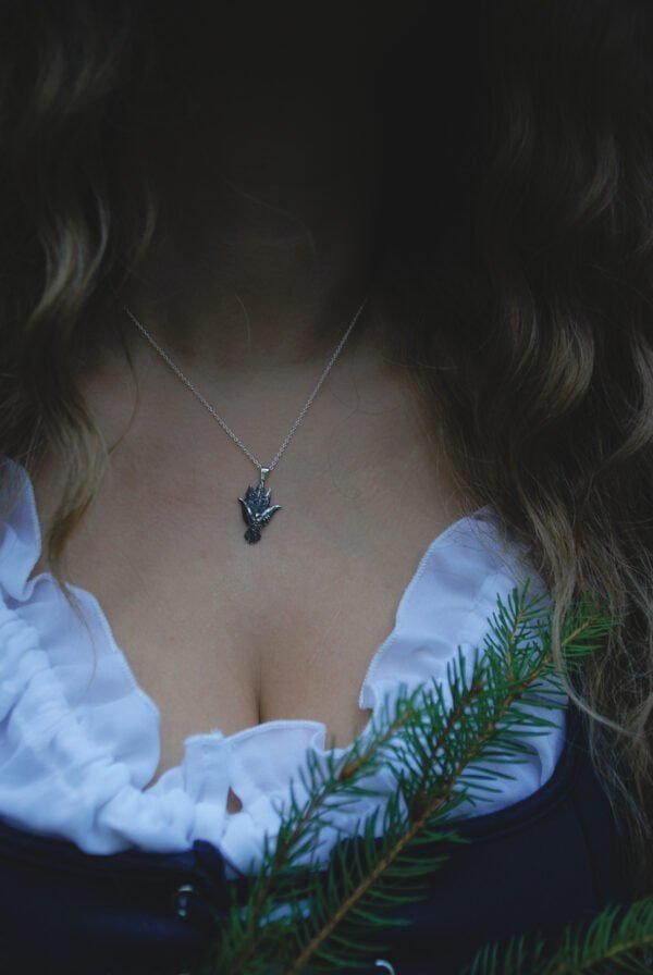 Woman wearing the silver owl pendant necklace in a forest-themed outfit, paired with a white ruffled blouse.