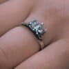 Diser silver ring worn on a hand, highlighting the intricate pine tree design.