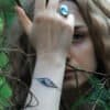 Nattuggla" silver bracelet worn in a mystical forest setting, paired with matching jewelry.