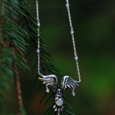 Handcrafted silver necklace featuring an owl pendant holding a glass opal, inspired by Nordic mythology.