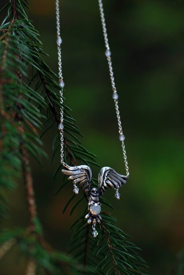 Handcrafted silver necklace featuring an owl pendant holding a glass opal, inspired by Nordic mythology.