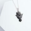 Detailed view of the owl pendant with engraved forest trees, symbolizing nature and protection.