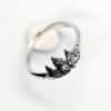 Close-up of the Diser silver ring with detailed pine tree design on a white background.