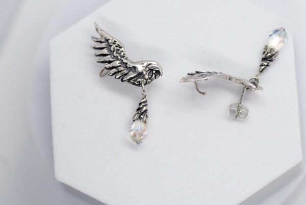 Pair of silver owl earrings with opal glass drops shown flat on white background.