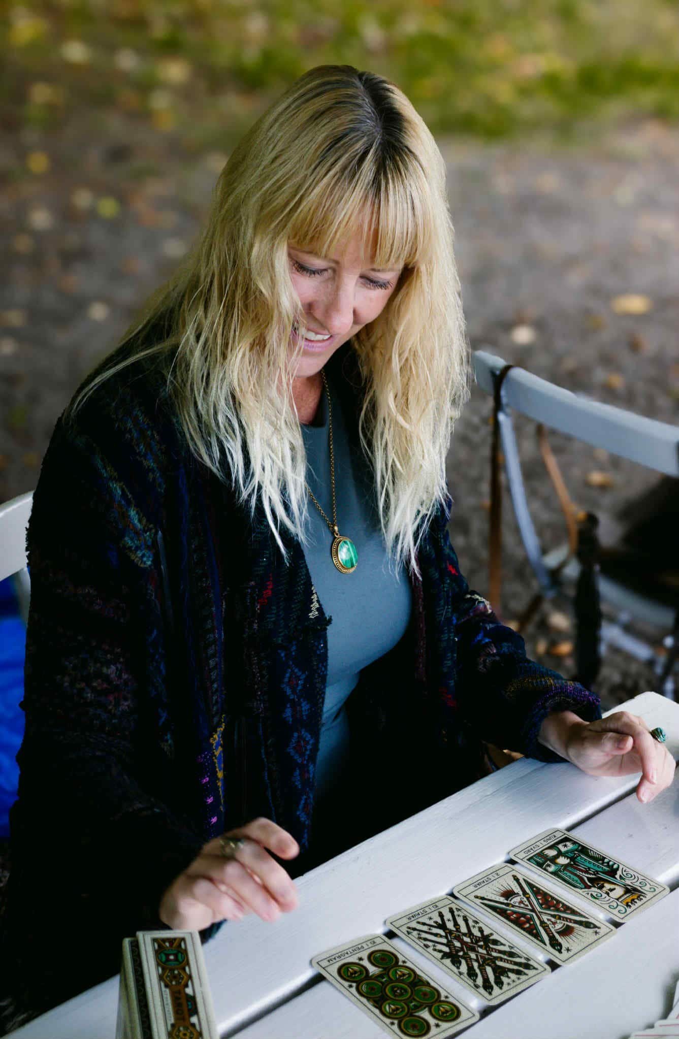 Witch reading tarot cards outdoors in nature, Mistwillow spiritual guidance photography